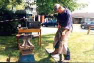 The Farrier fashions a horse shoe