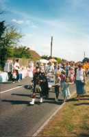 The Piper leads the Tug of War teams along Swallowfield Road