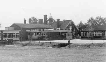 The school, with extensions and temporary 'terrapin' buildings