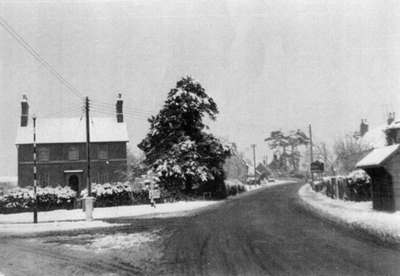 The crossroads looking southwards, with old bus shelter in right foreground