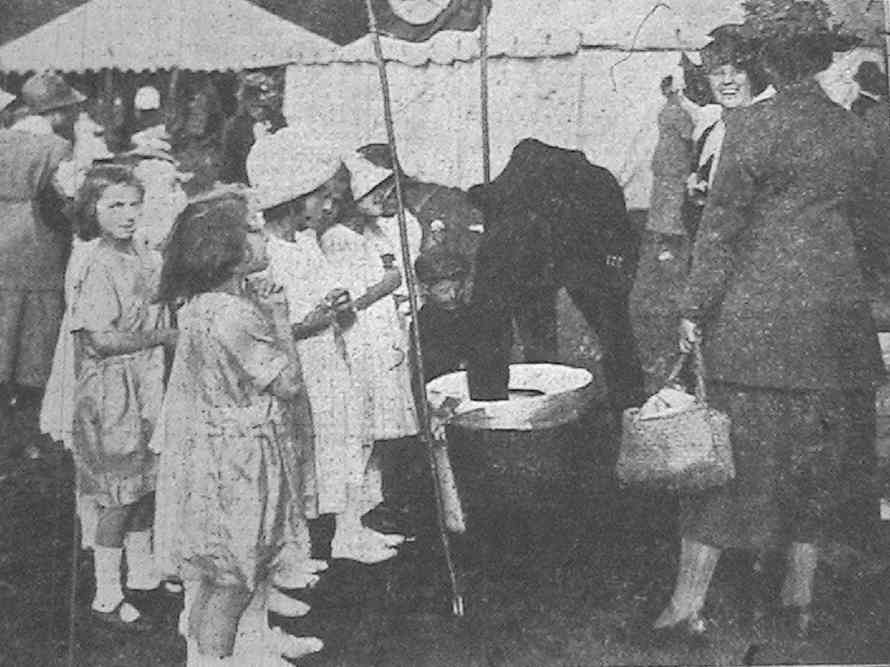 Village Policeman, Miss Bishop and children at the bran dip