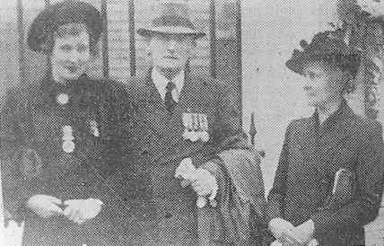 Mr. and Mrs. Watts and their daughter, with medals